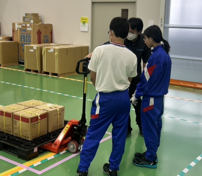 Students receiving instructions on how to operate a hand lift